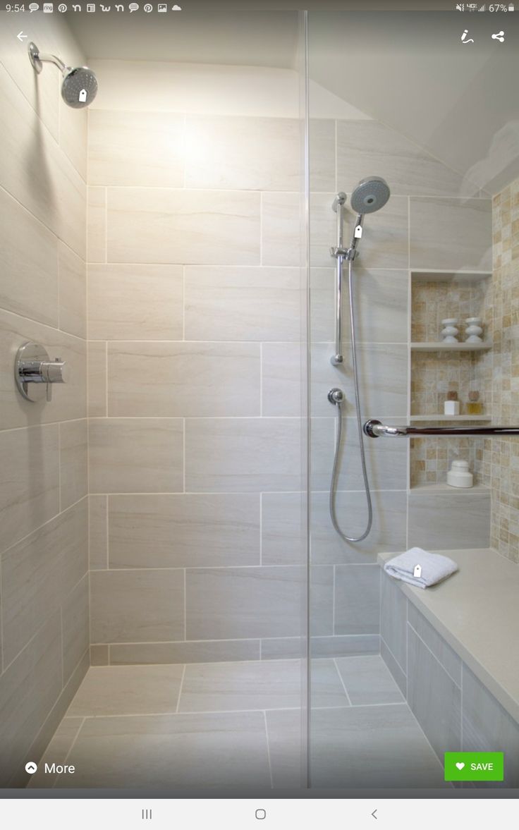 a walk in shower sitting next to a white counter top under a light on the wall