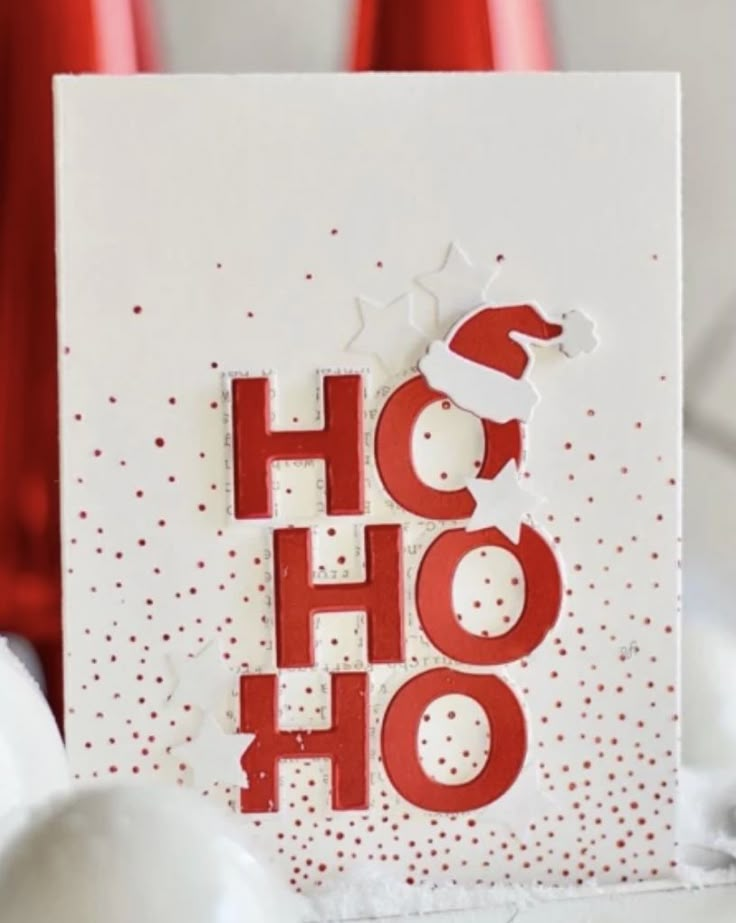 a card with the word ho hoo on it and some red vases in the background