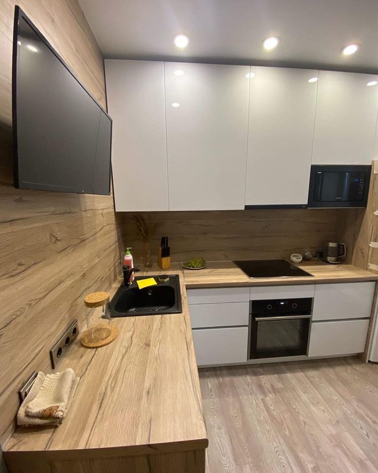 a kitchen with white cabinets and wooden counter tops is shown in this image, there are no people or objects on the counter