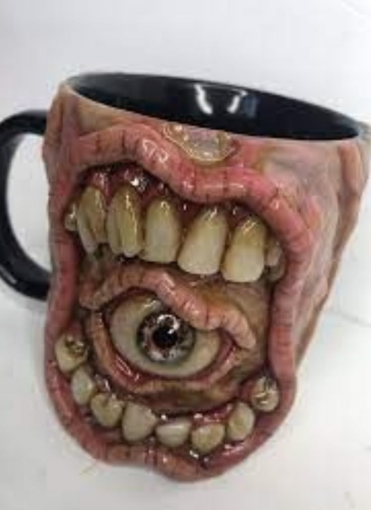 a coffee mug with an evil looking monster's mouth and teeth on the inside