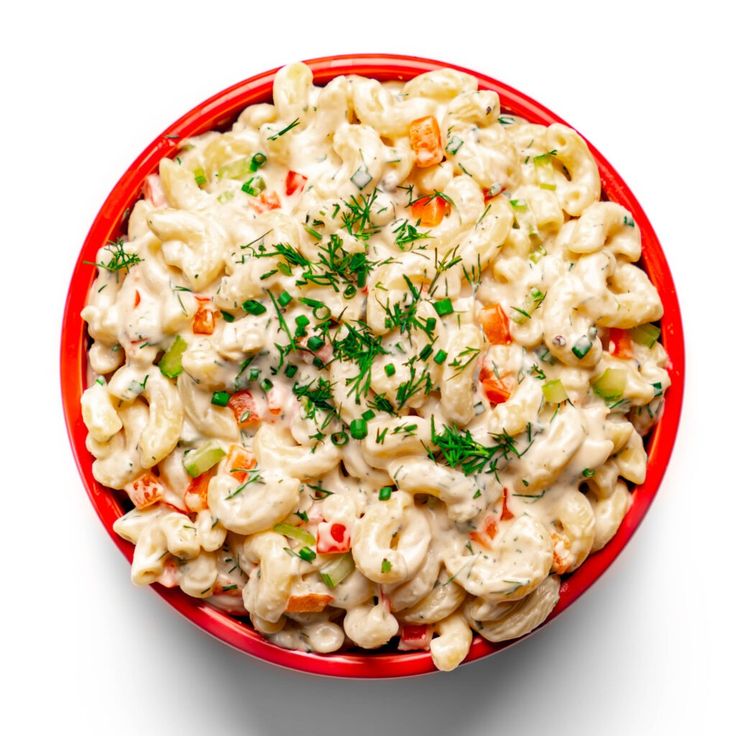 a red bowl filled with macaroni salad on top of a white tablecloth