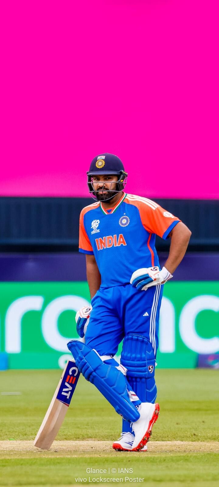 a man in blue and orange uniform playing a game of cricket