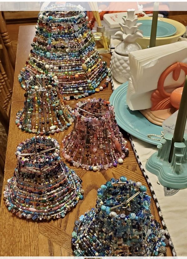 a table topped with lots of different types of necklaces on top of wooden tables