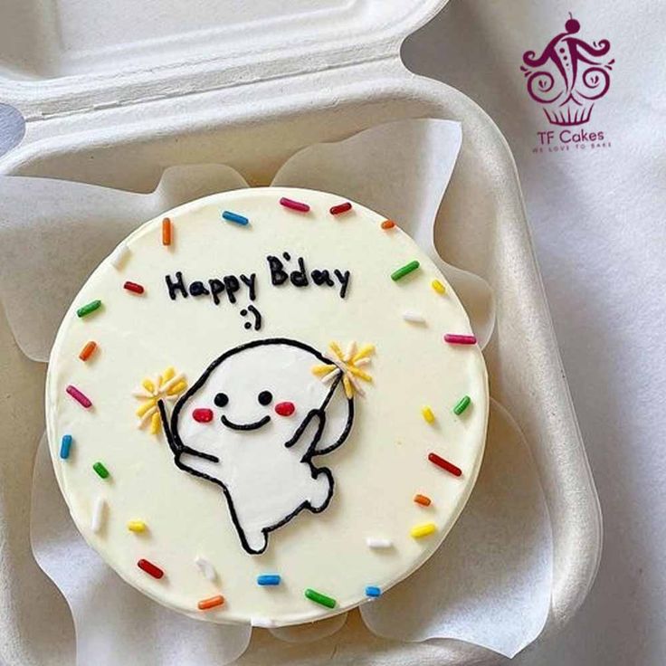 a birthday cake in a white box with sprinkles and an elephant on it