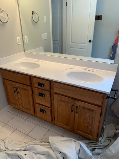 a bathroom vanity with two sinks and a large mirror above it, in the process of being remodeled