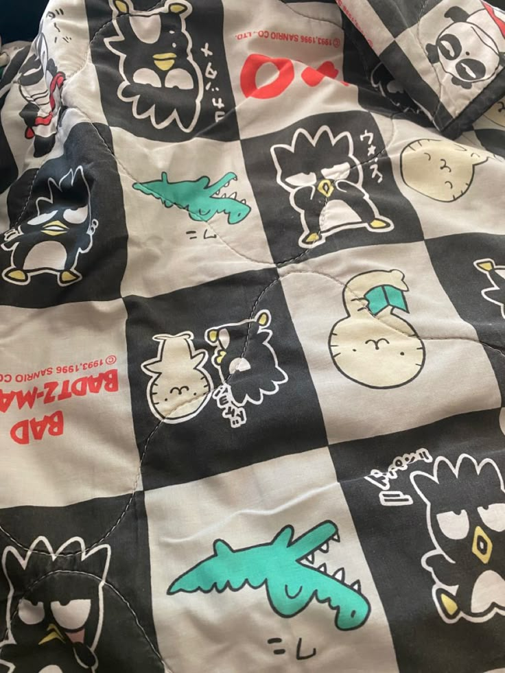 a black and white checkered blanket with various cartoon characters on it's side