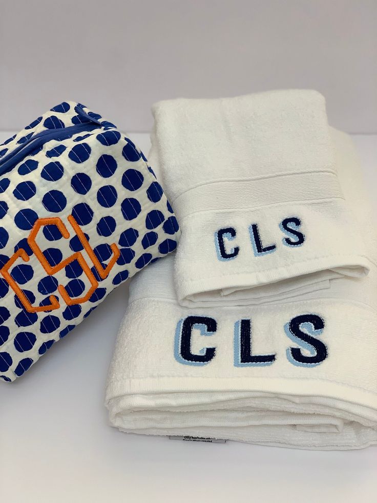 two personal towels are sitting next to each other on a white tablecloth with blue and orange polka dots