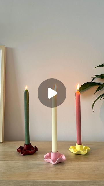 three candles sitting on top of a table next to a potted plant