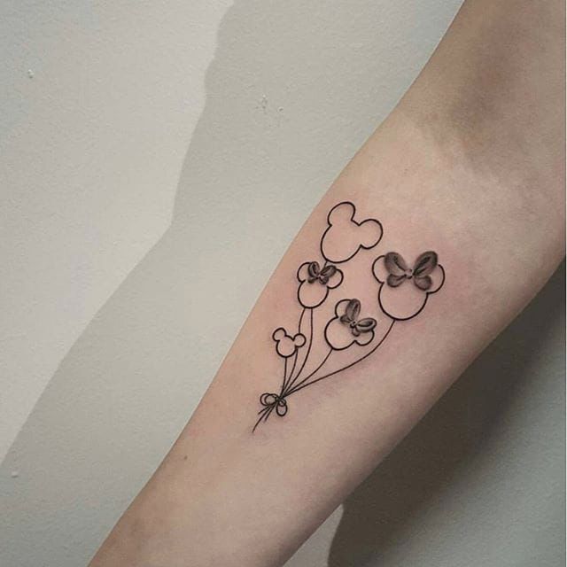 a small tattoo on the arm of a girl with flowers and hearts in black ink