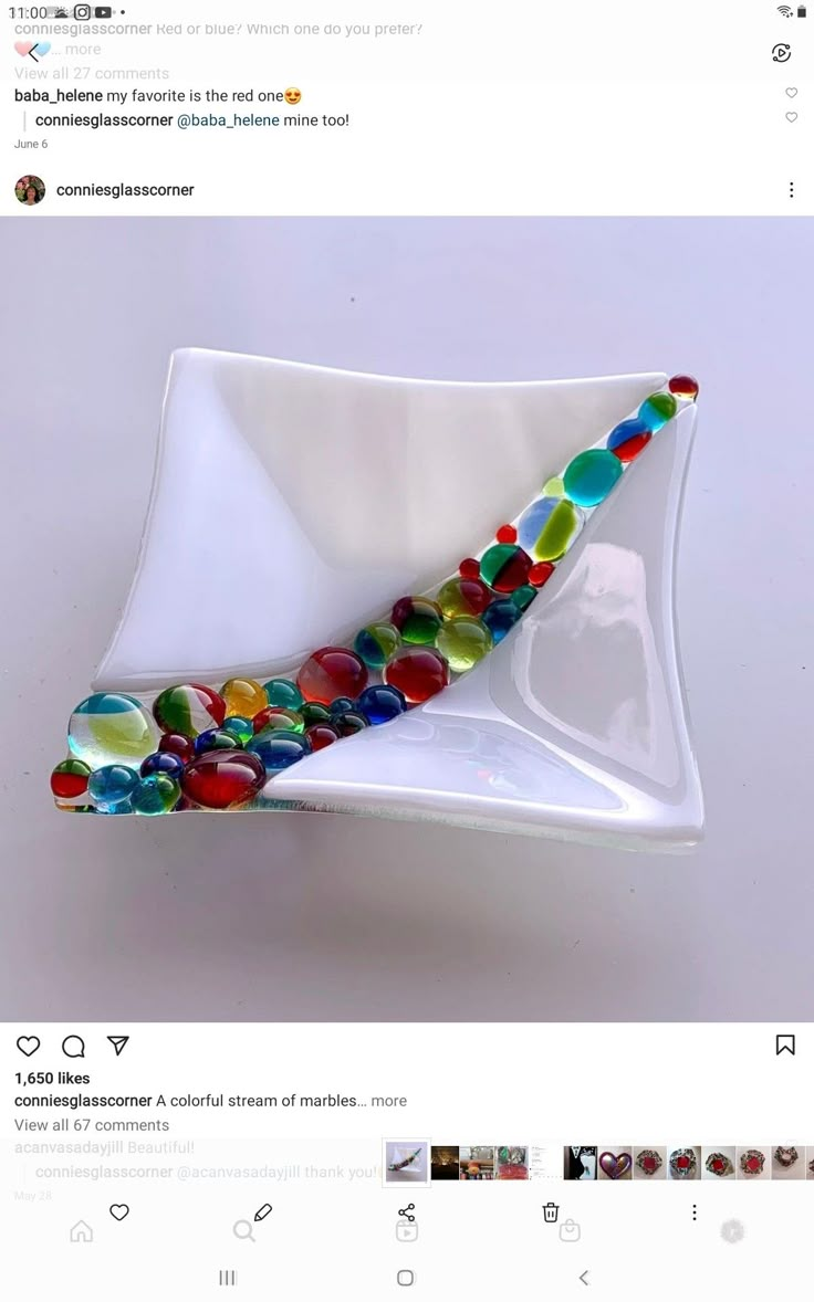 a white bowl with colorful glass beads on it