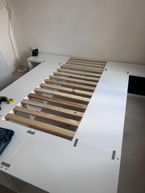 a bed frame is being built on top of a table in a room with white walls and flooring