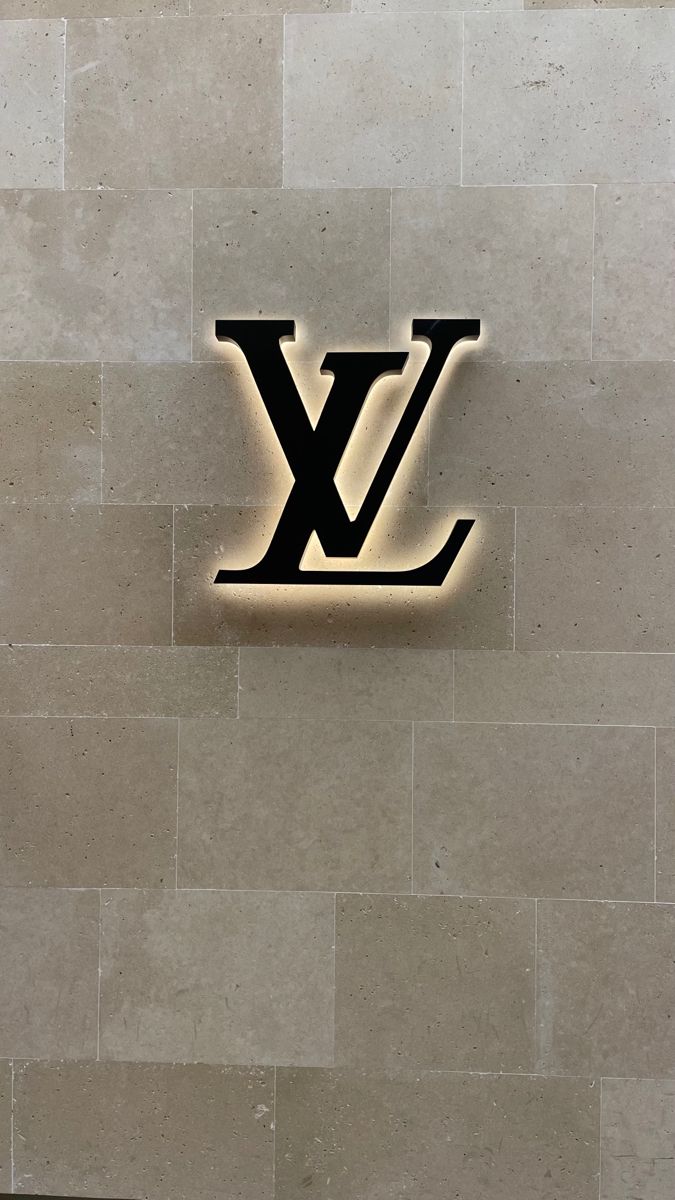 the louis vuitton logo is lit up against a wall