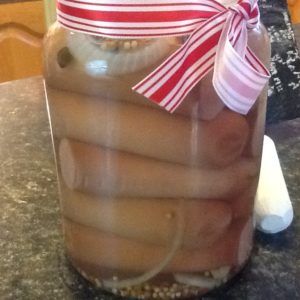 a jar filled with hot dogs sitting on top of a counter