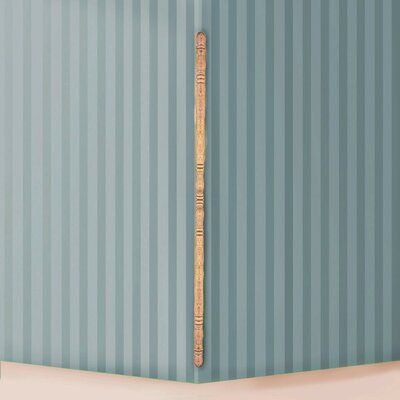 a baseball bat leaning against the wall in a room with blue striped walls and white flooring