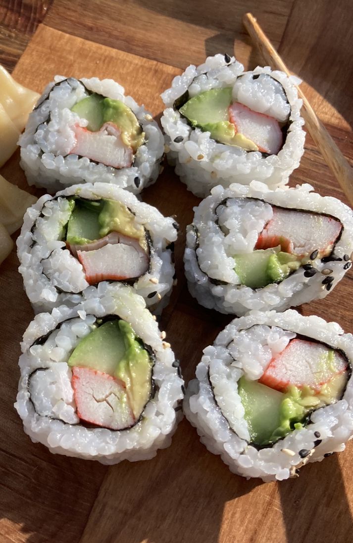 several sushi rolls are arranged on a cutting board