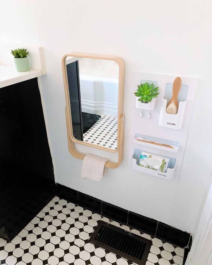 a bathroom with a sink, mirror and black and white tile flooring in it