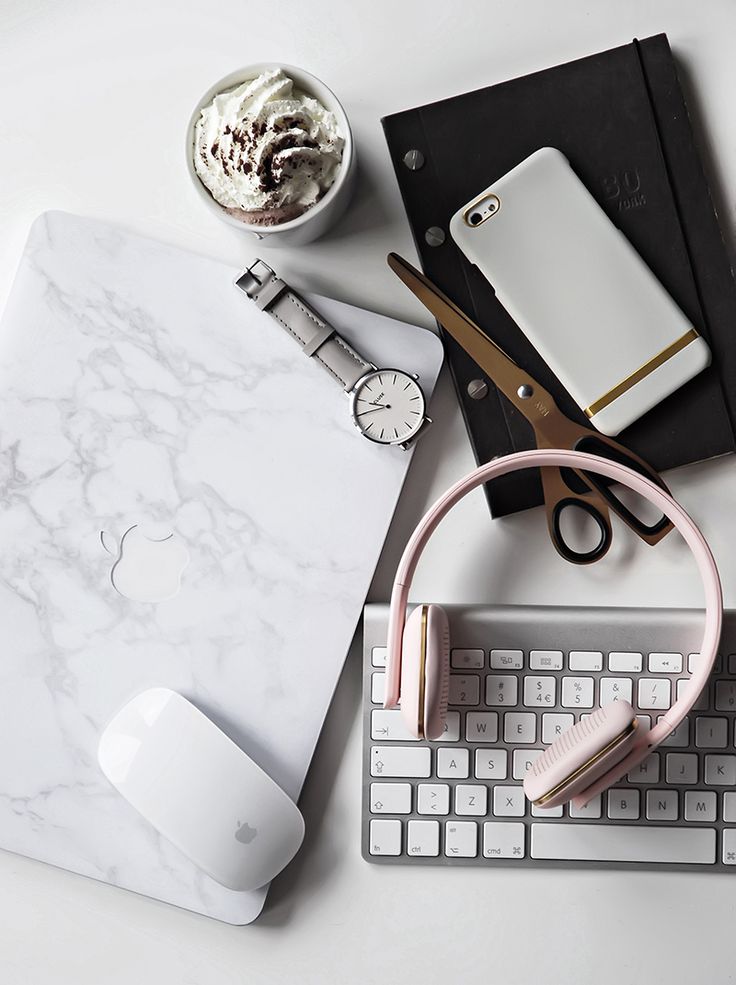 an assortment of office supplies on top of a white desk with a keyboard and mouse