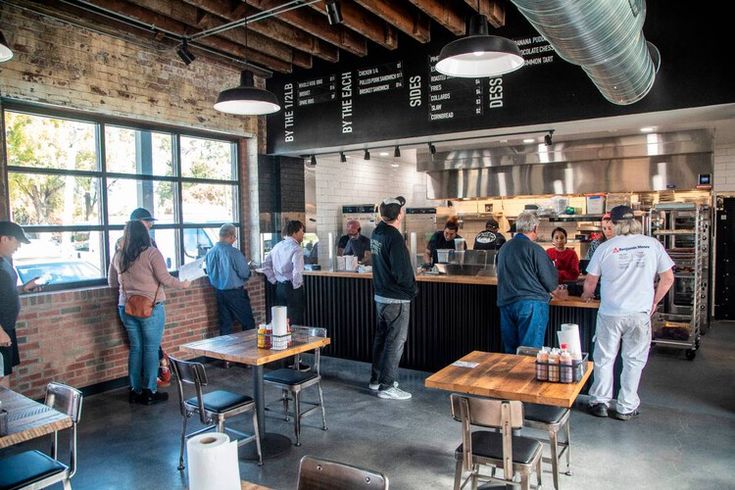 people are standing in line to order food at the eatery counter and check out their menus