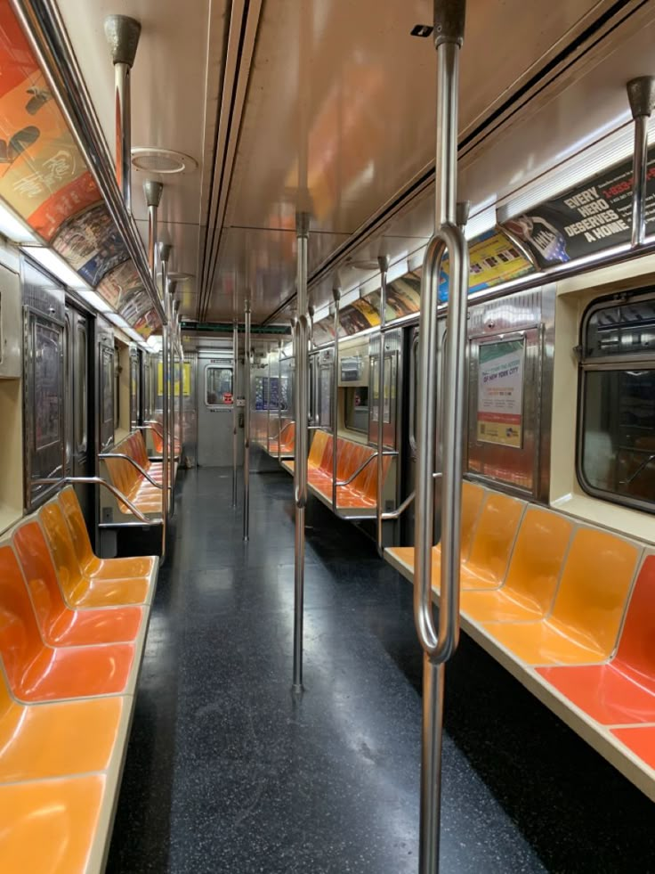 an empty subway car with orange and yellow seats