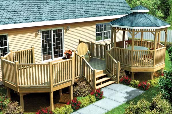 a wooden deck and gazebo in front of a house