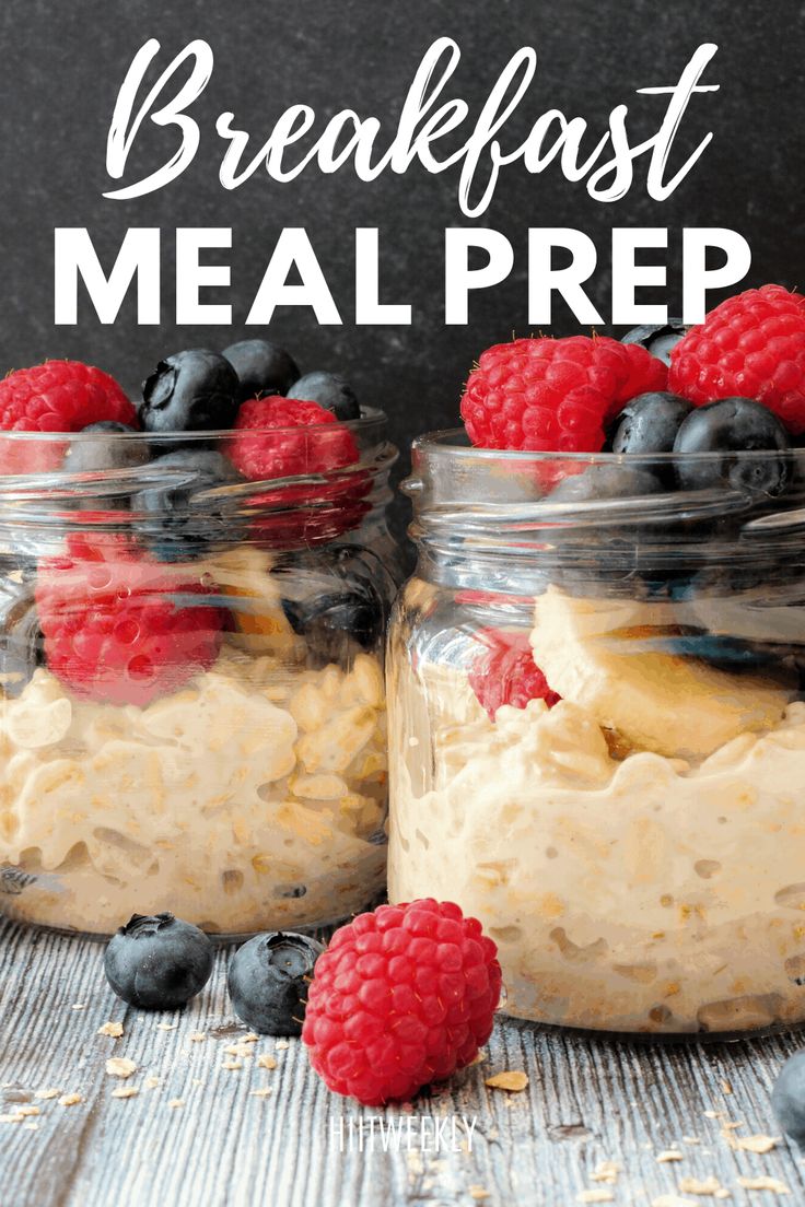 two mason jars filled with breakfast meal preps and topped with fresh berries, bananas, and blueberries