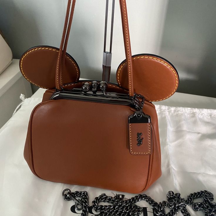 Authentic Retail Version Sold Out In Stores And Online Glovetanned Leather Inside Multifunctional Pocket Double Kisslock Closure, Leather Lining Handle With 4 1/2 Drop Detachable Strap With 22 1/2” Drop For Shoulder Or Crossbody Wear 6” X 4.25” X 3.75” Disney X Coach Retail For $528 + Tax Comes With Dust Bag Never Used, Floor Model, Priced Accordingly Disney Coach, Disney Bag, Minnie Mouse Ears, Mouse Ears, Coach Bags, Minnie Mouse, Vision Board, Crossbody Bag, Dust Bag