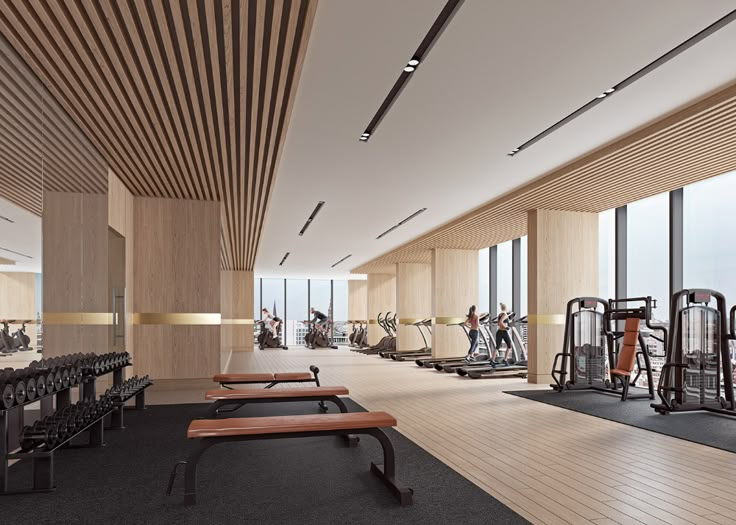 an empty gym with rows of treadmills and benches