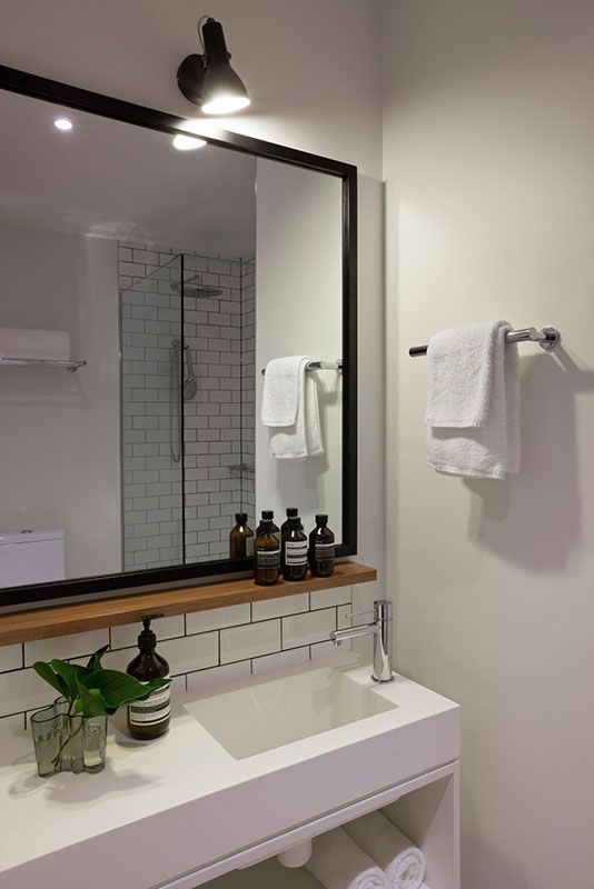 a bathroom with a sink, mirror and towel rack