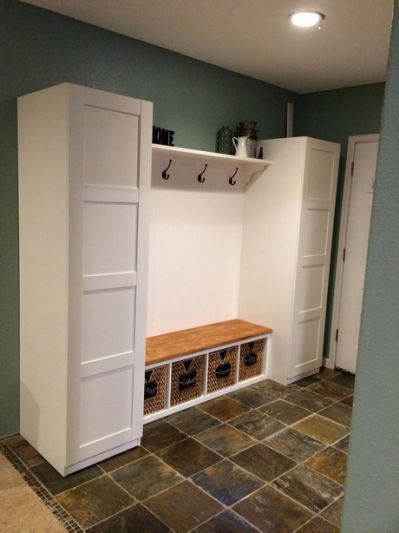 a room that has some white cabinets and shelves in it with baskets on the floor