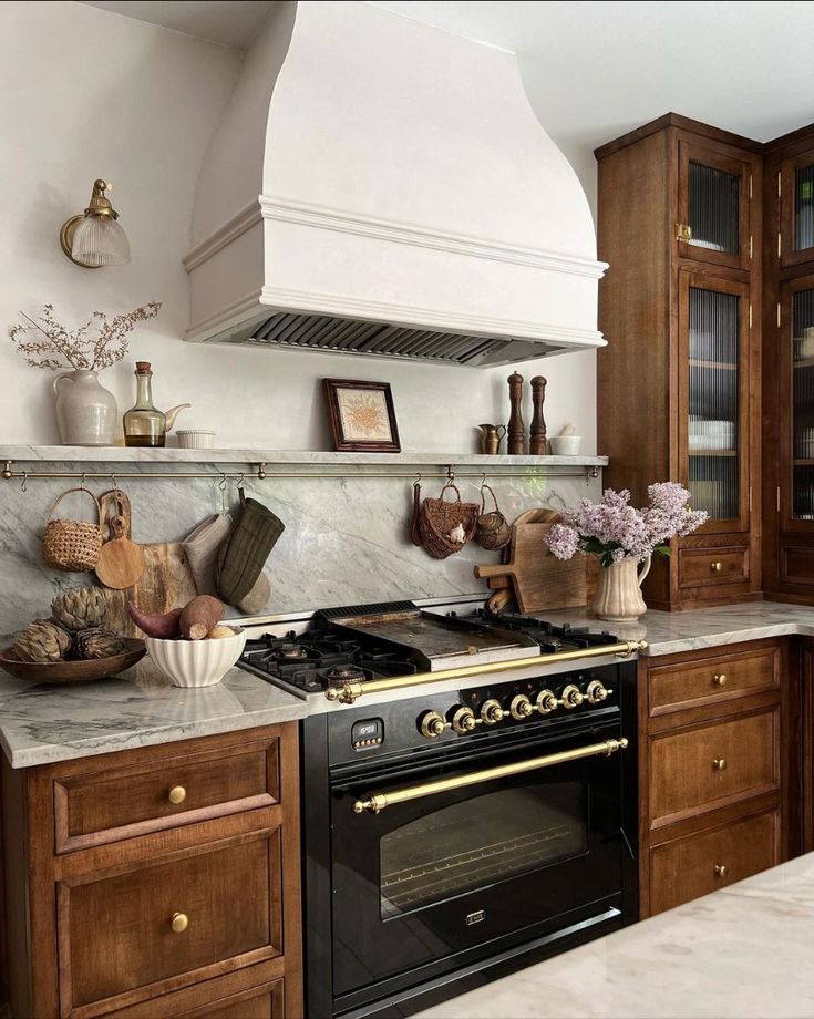 a stove top oven sitting inside of a kitchen next to wooden cupboards and counter tops