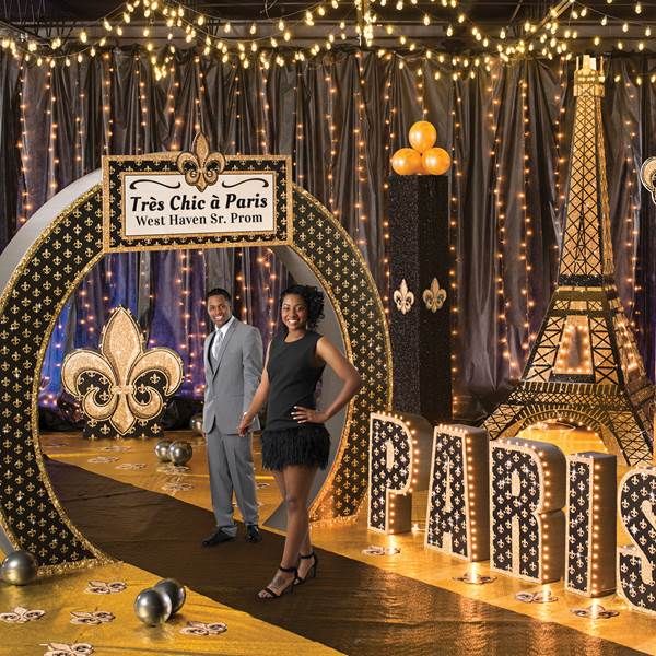 a man and woman standing in front of the eiffel tower at christmas time