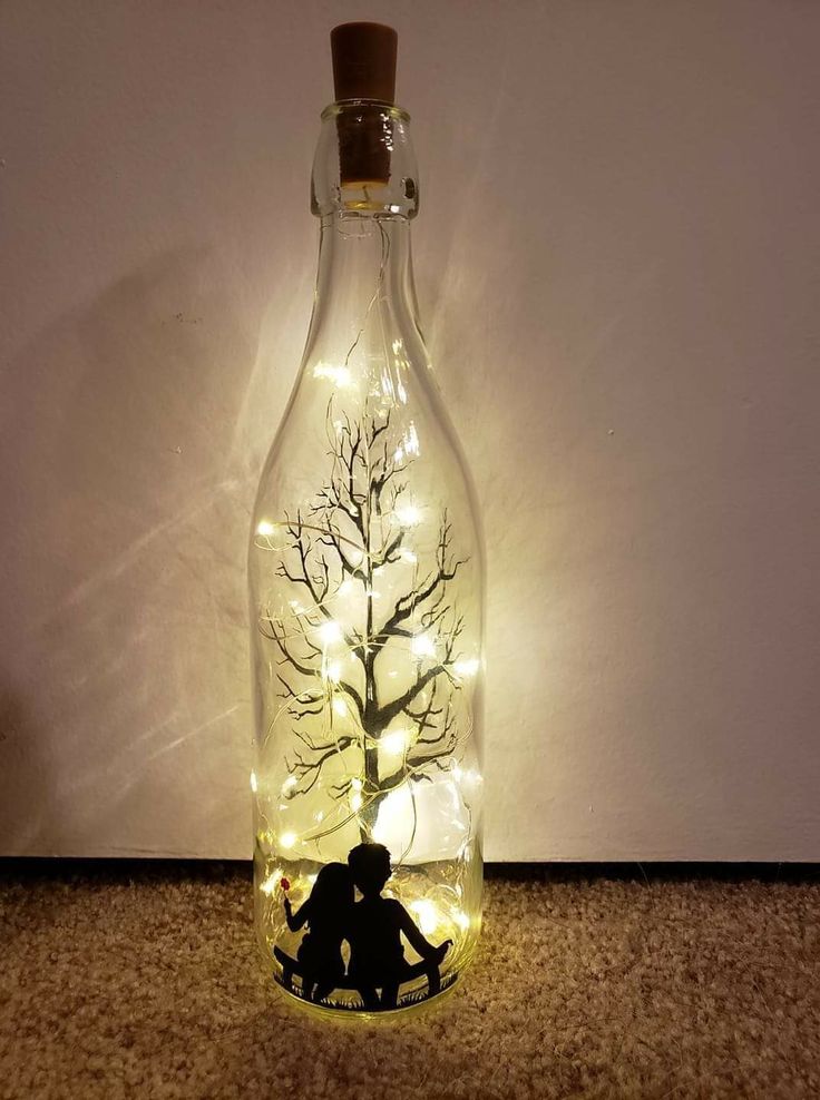 a bottle with a tree in it and some lights inside