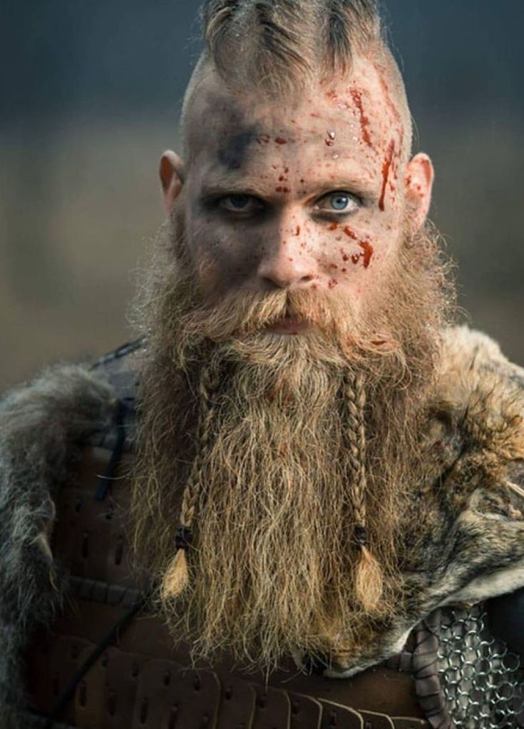 an image of a man with blood on his face and beard, wearing leather armor