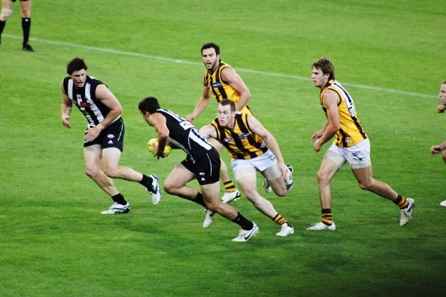 a group of men running on top of a field