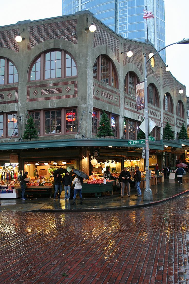 people are walking around in the rain at an outdoor fruit and veggie market