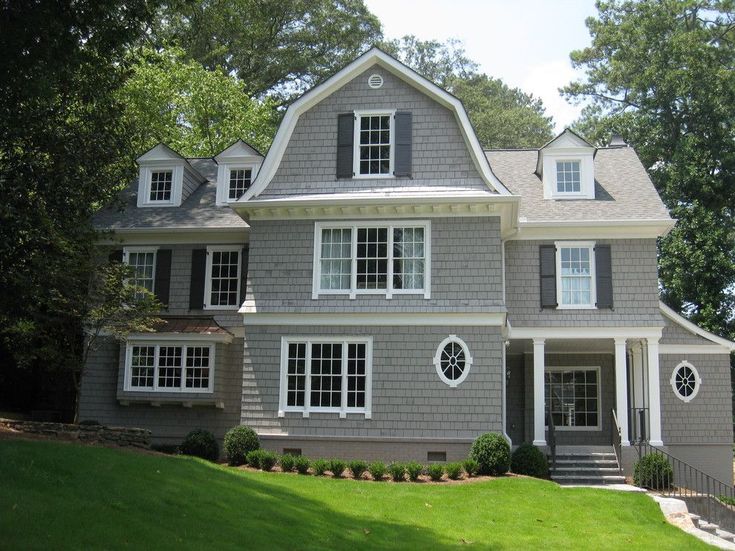 a large gray house with white trim and windows