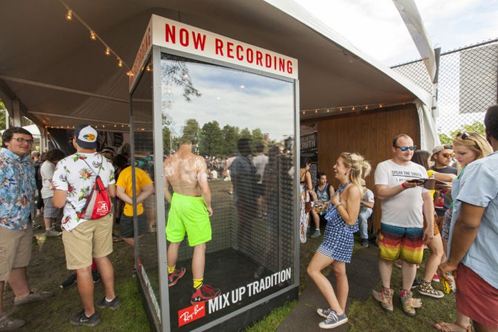 a group of people standing in front of a record player at an outdoor music festival