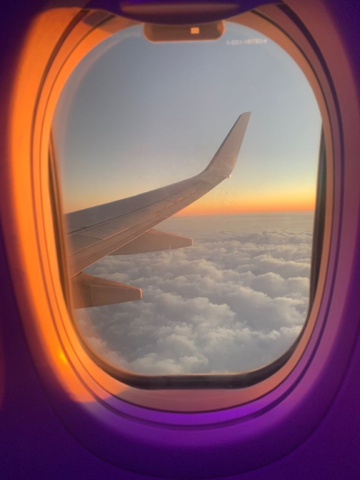 an airplane window looking out at the clouds