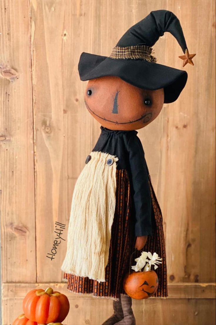 a scarecrow doll is standing next to pumpkins