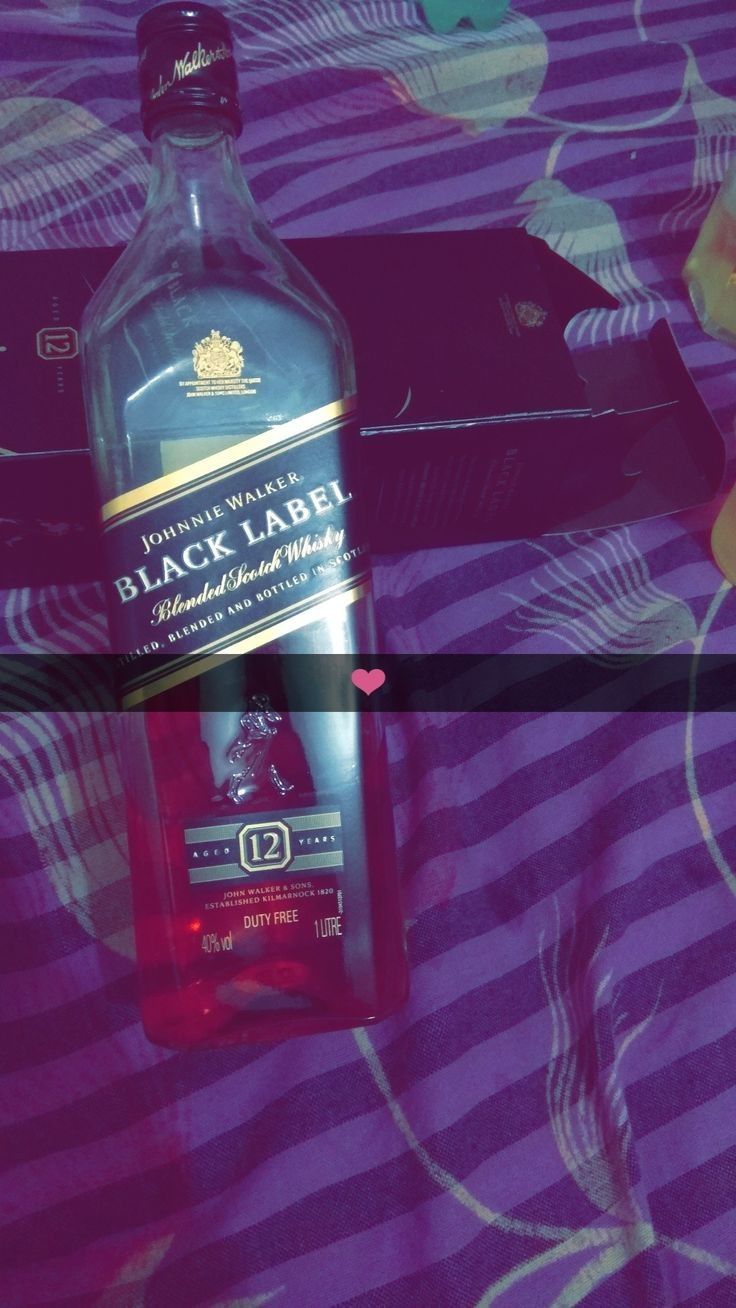 a bottle of alcohol sitting on top of a bed