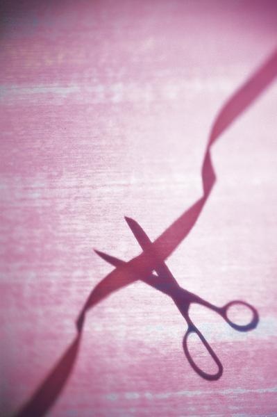 the shadow of a pair of scissors on a pink background