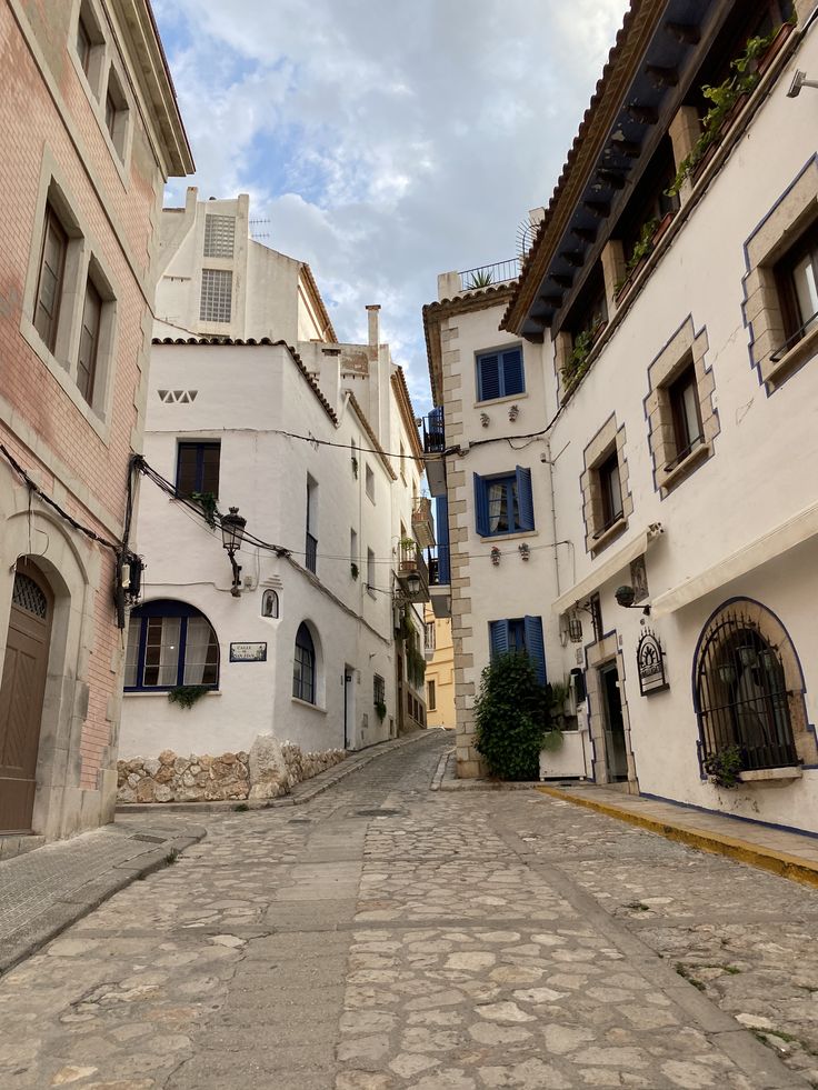 an empty cobblestone street with buildings on both sides