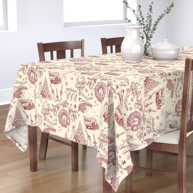 a dining room table covered with a flowered tablecloth next to two vases