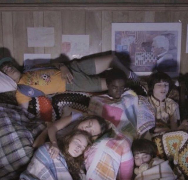 a group of young people laying in bed together