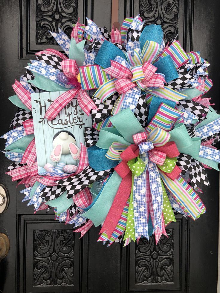 a close up of a wreath on a door with an easter bunny and checkered bow