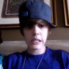 a young boy wearing a baseball cap while sitting on a couch