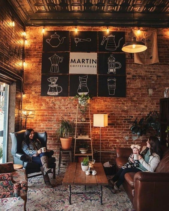 two people sitting in leather chairs in front of a brick wall with writing on it