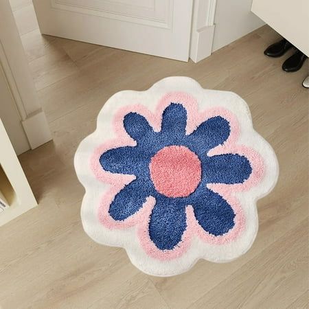 a blue and pink flower rug sitting on top of a wooden floor next to a door