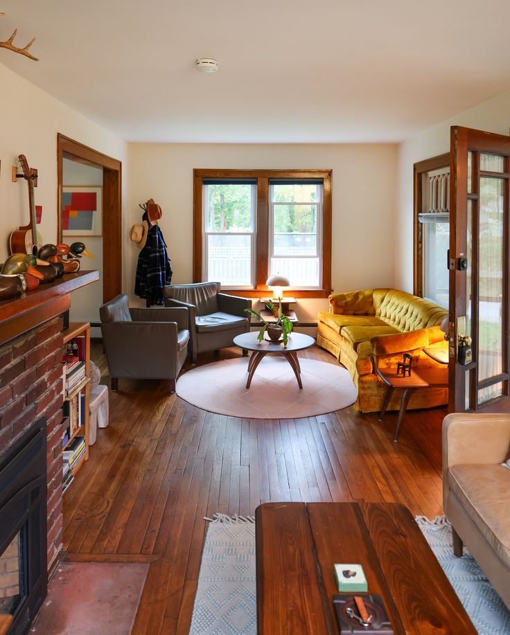 a living room filled with furniture and a fire place next to a window on the wall