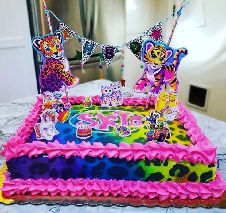 a birthday cake is decorated with colorful icing and animal decorations on it's edges